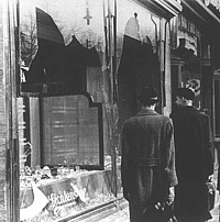 citizens in Berlin walk by smashed Jewish shop